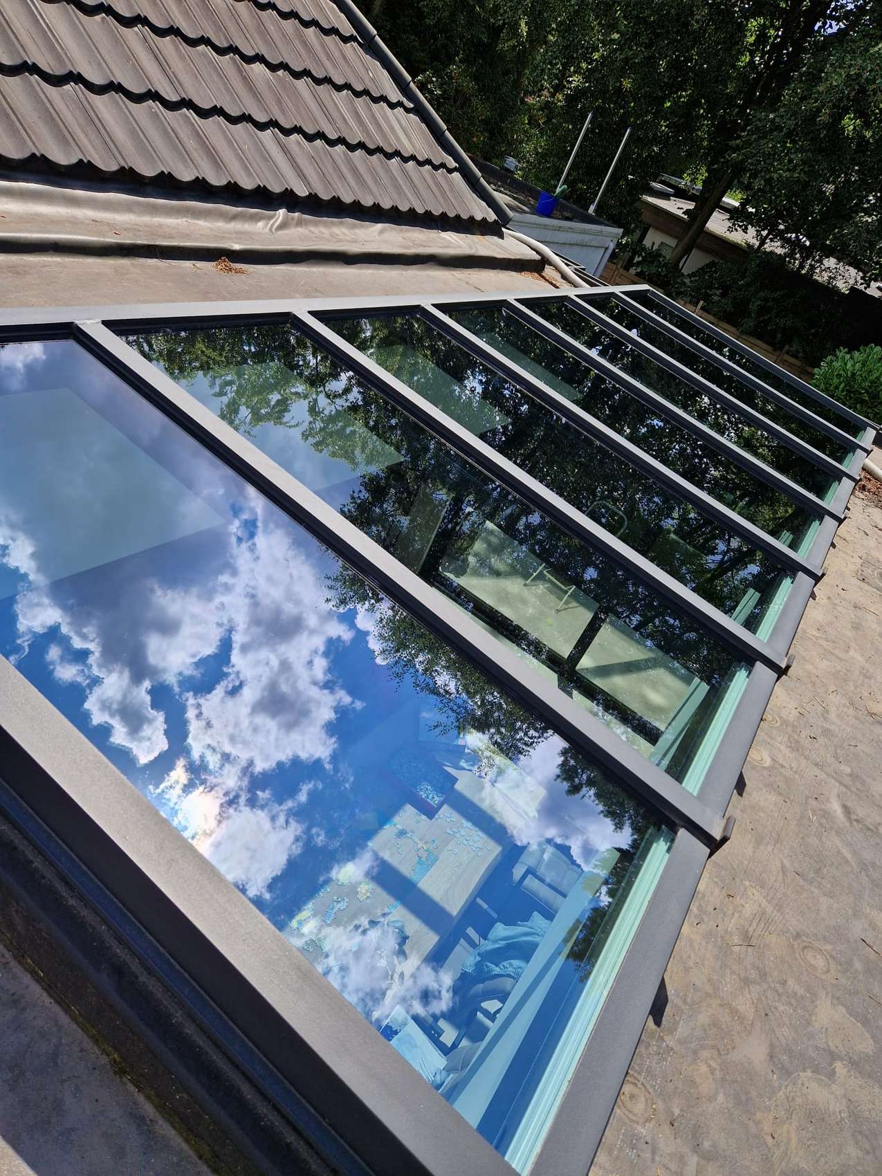 Glasdak met wolken in de weerspiegeling